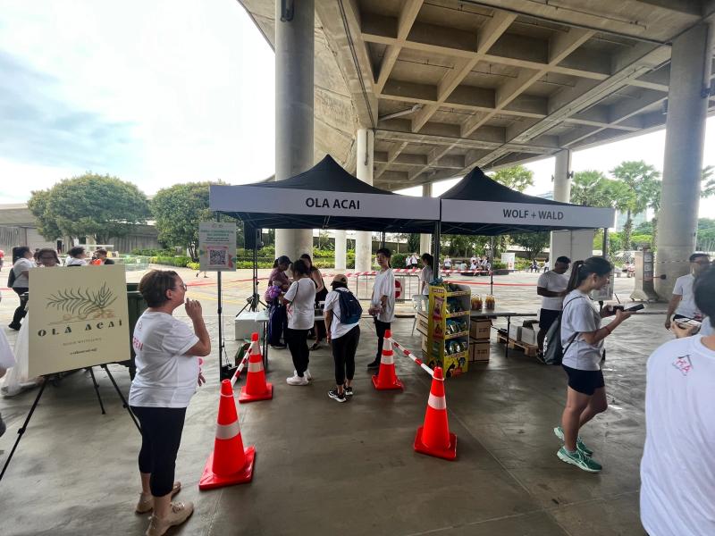 Olá Açaí event tent set up outdoors at a community run