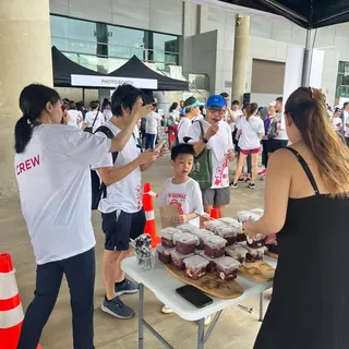 Handing out açaí cups to a crowd at a community event